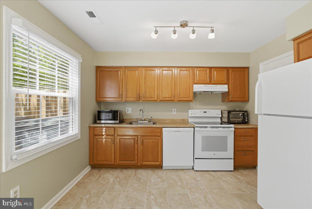 8582 Adamson Street Manassas, VA 20110 - Photo 9 of 24 a kitchen with stainless steel appliances granite countertop a stove a sink dishwasher a refrigerator and a microwave