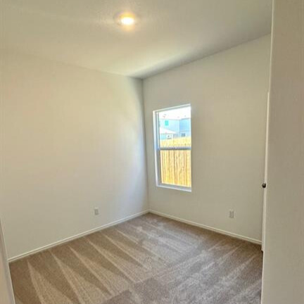 340 The Bad Way Jarrell, TX 76537 - Photo 2 of 14 Empty room featuring light carpet and baseboards