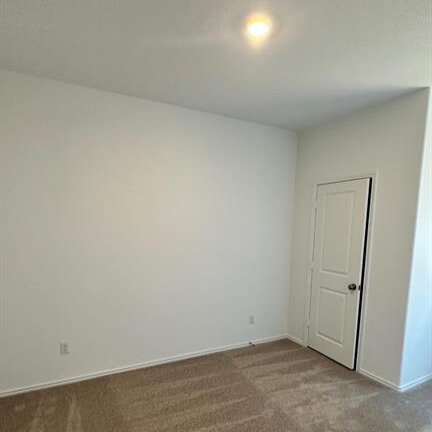 340 The Bad Way Jarrell, TX 76537 - Photo 3 of 14 Empty room with dark carpet and baseboards