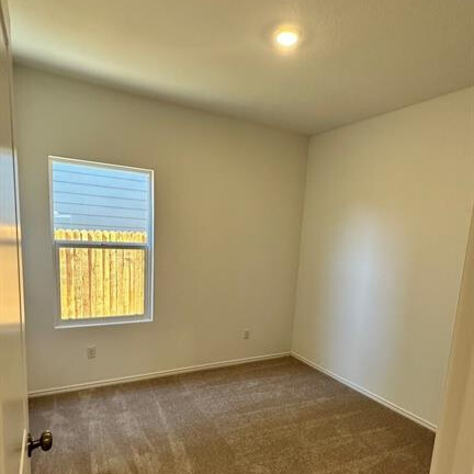 340 The Bad Way Jarrell, TX 76537 - Photo 4 of 14 Empty room with dark colored carpet and baseboards