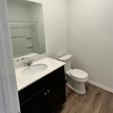 340 The Bad Way Jarrell, TX 76537 - Photo 7 of 14 Bathroom with dark wood finished floors, vanity, and tub / shower combination