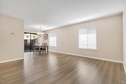 an empty room with wooden floor and dining room