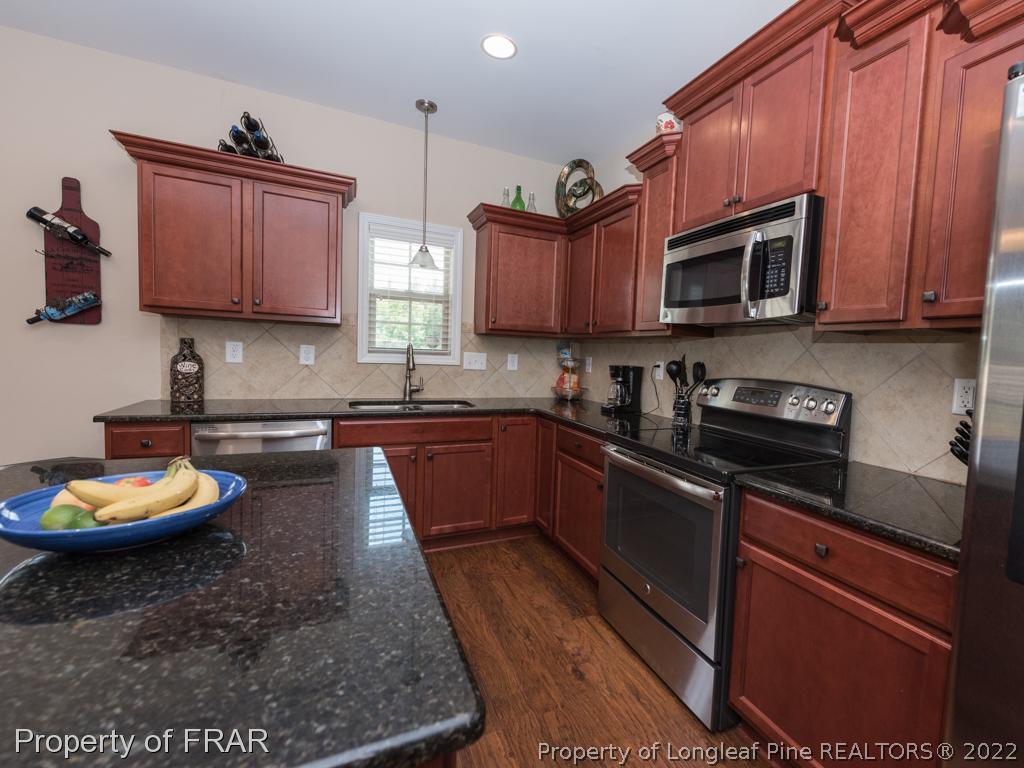717 St Johns Loop Raeford, NC 28376 - Photo 12 of 29 a kitchen with stainless steel appliances granite countertop a stove a sink dishwasher and a microwave oven with granite countertops