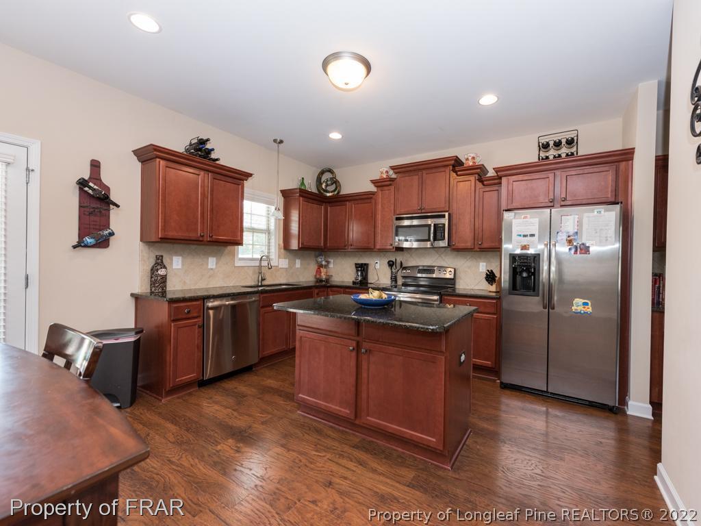 717 St Johns Loop Raeford, NC 28376 - Photo 13 of 29 a kitchen with stainless steel appliances granite countertop a refrigerator stove and oven