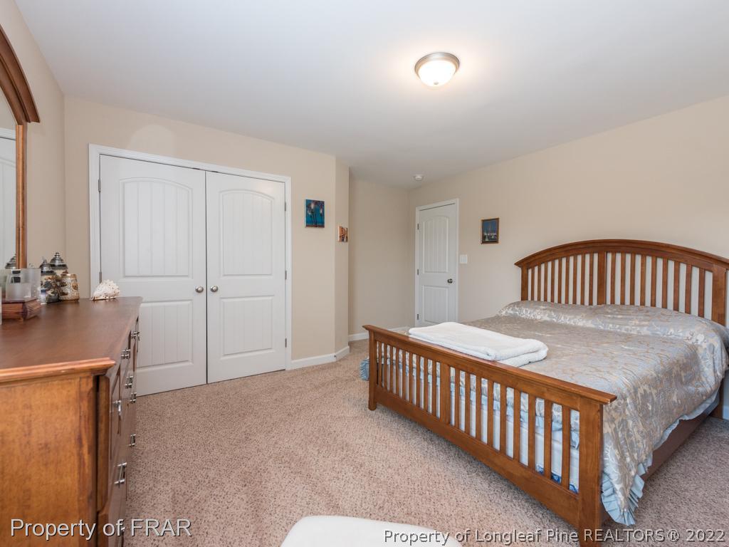 717 St Johns Loop Raeford, NC 28376 - Photo 15 of 29 a bedroom with a bed and wooden floor