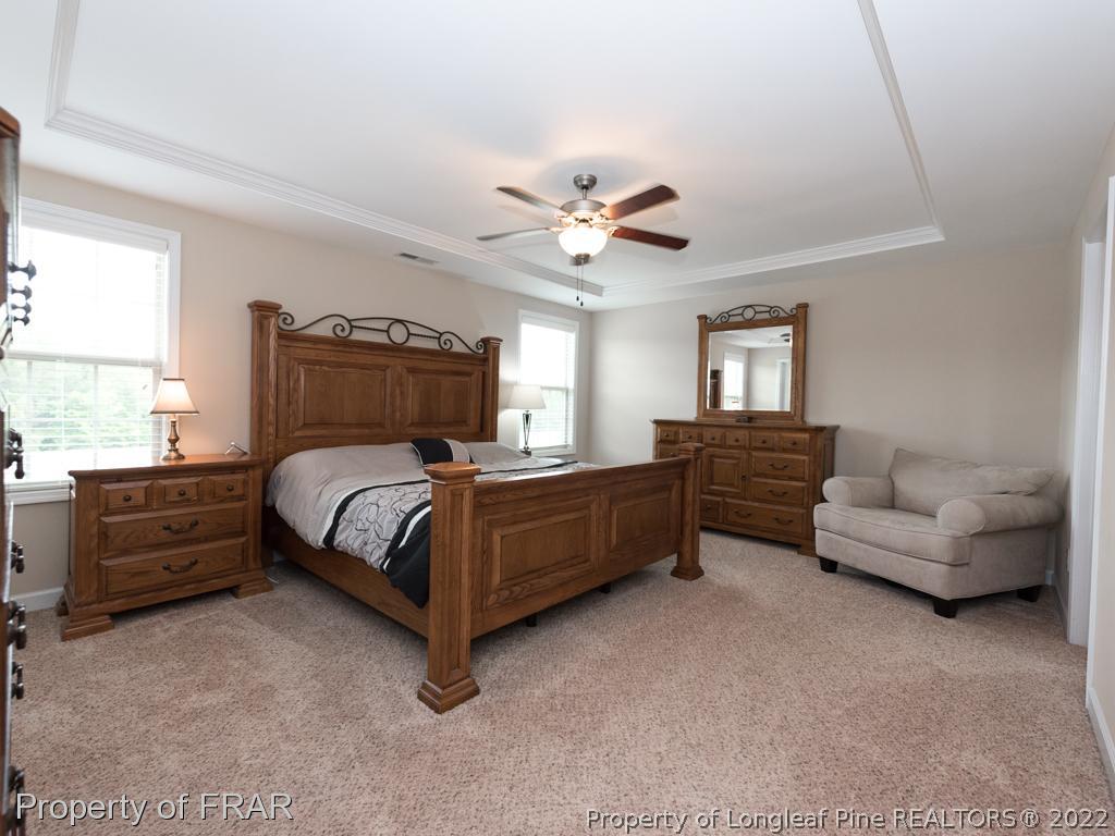 717 St Johns Loop Raeford, NC 28376 - Photo 16 of 29 a bedroom with a bed and a chandelier