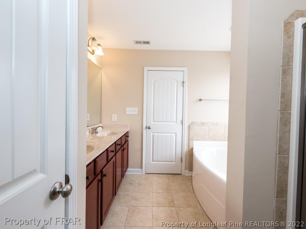 717 St Johns Loop Raeford, NC 28376 - Photo 18 of 29 a bathroom with a granite countertop sink and a mirror