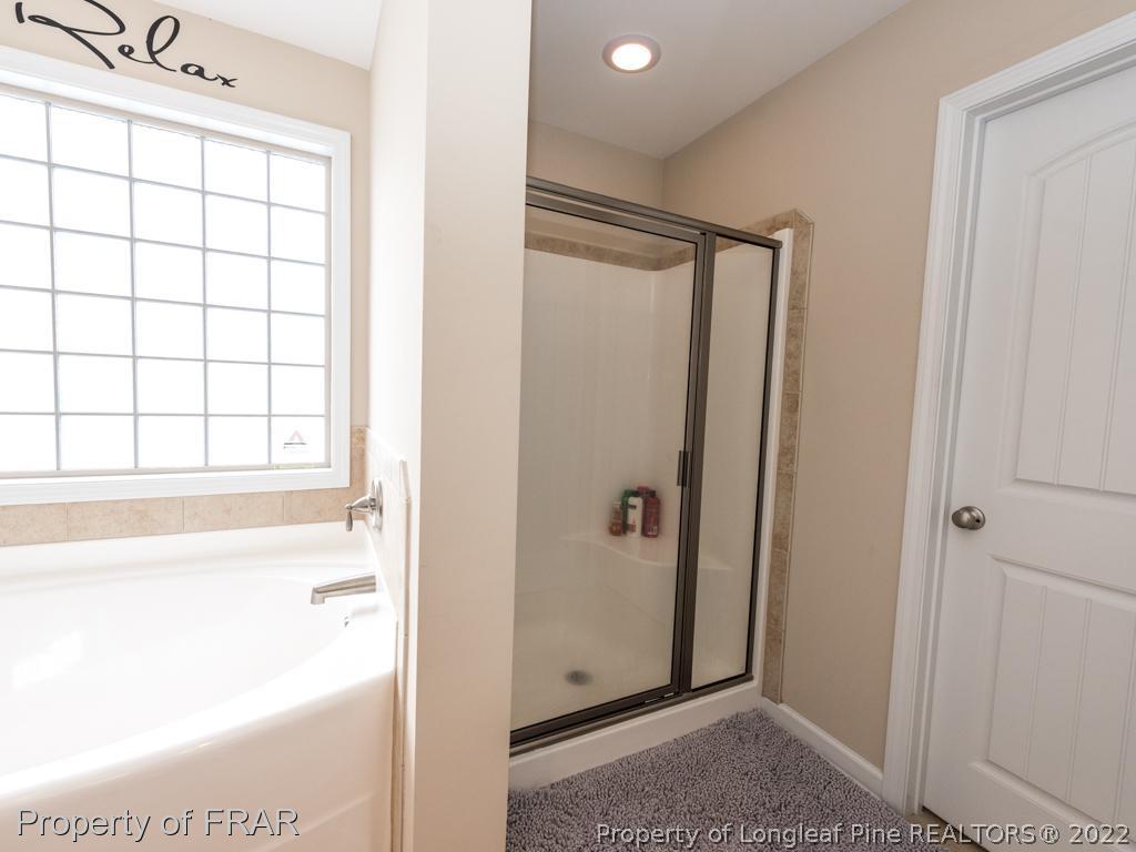 717 St Johns Loop Raeford, NC 28376 - Photo 20 of 29 a bathroom with a bathtub and a shower