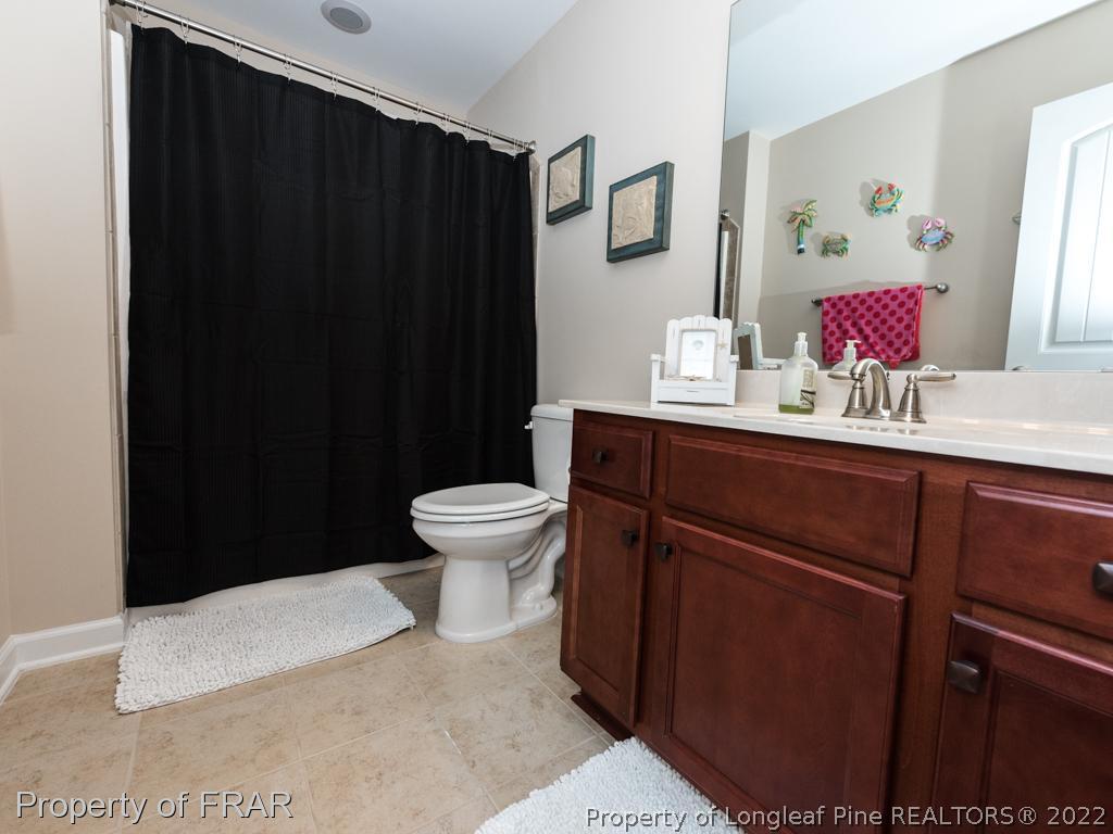 717 St Johns Loop Raeford, NC 28376 - Photo 25 of 29 a bathroom with a sink vanity mirror and toilet