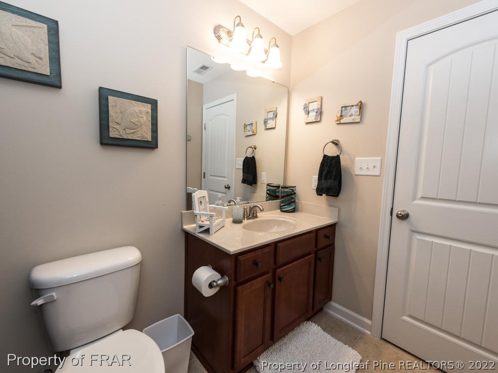 717 St Johns Loop Raeford, NC 28376 - Photo 26 of 29 a bathroom with a toilet sink and mirror