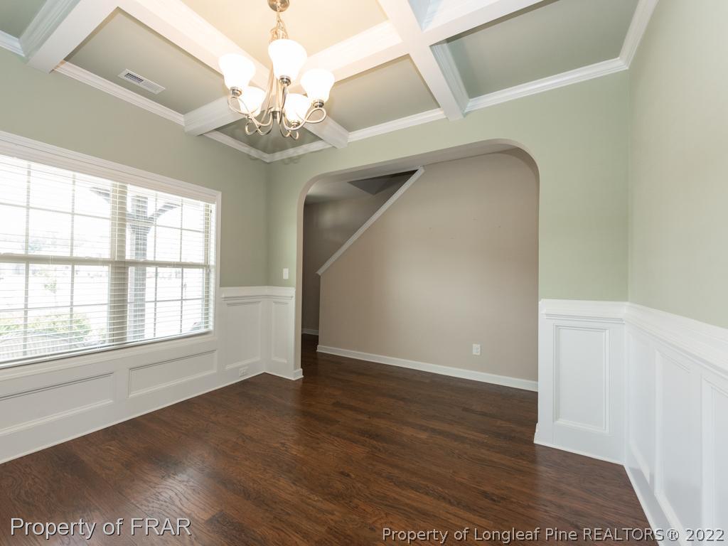 717 St Johns Loop Raeford, NC 28376 - Photo 6 of 29 an empty room with wooden floor chandelier and windows