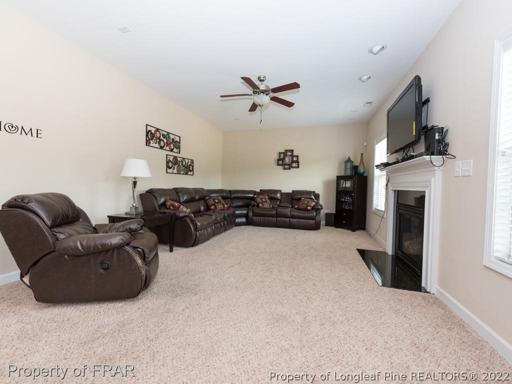 717 St Johns Loop Raeford, NC 28376 - Photo 8 of 29 a living room with furniture a fireplace and a flat screen tv