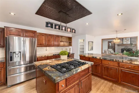 a kitchen with stainless steel appliances granite countertop a stove a sink dishwasher and a refrigerator