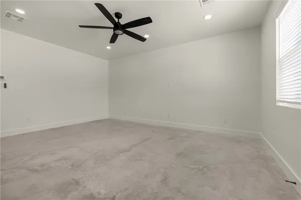 an empty room with a window and a fan