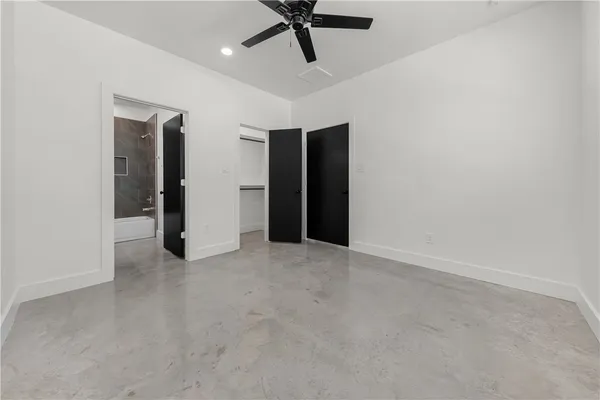 an empty room with a ceiling fan and carpet