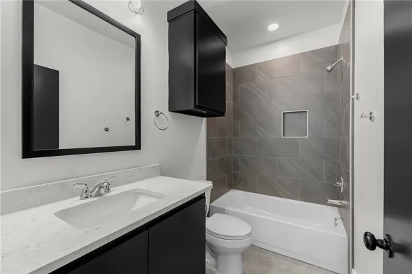 a bathroom with a bathtub shower sink and toilet