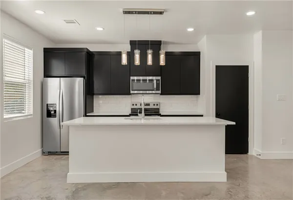 a kitchen with stainless steel appliances granite countertop a refrigerator and a sink