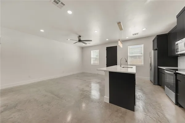 a kitchen with kitchen island a sink stainless steel appliances and cabinets