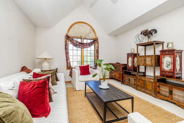 a living room with furniture a flat screen tv and a table