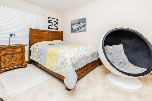 a bed room with a bed and a painting on the wall