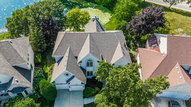 an aerial view of house with yard and trees in the background
