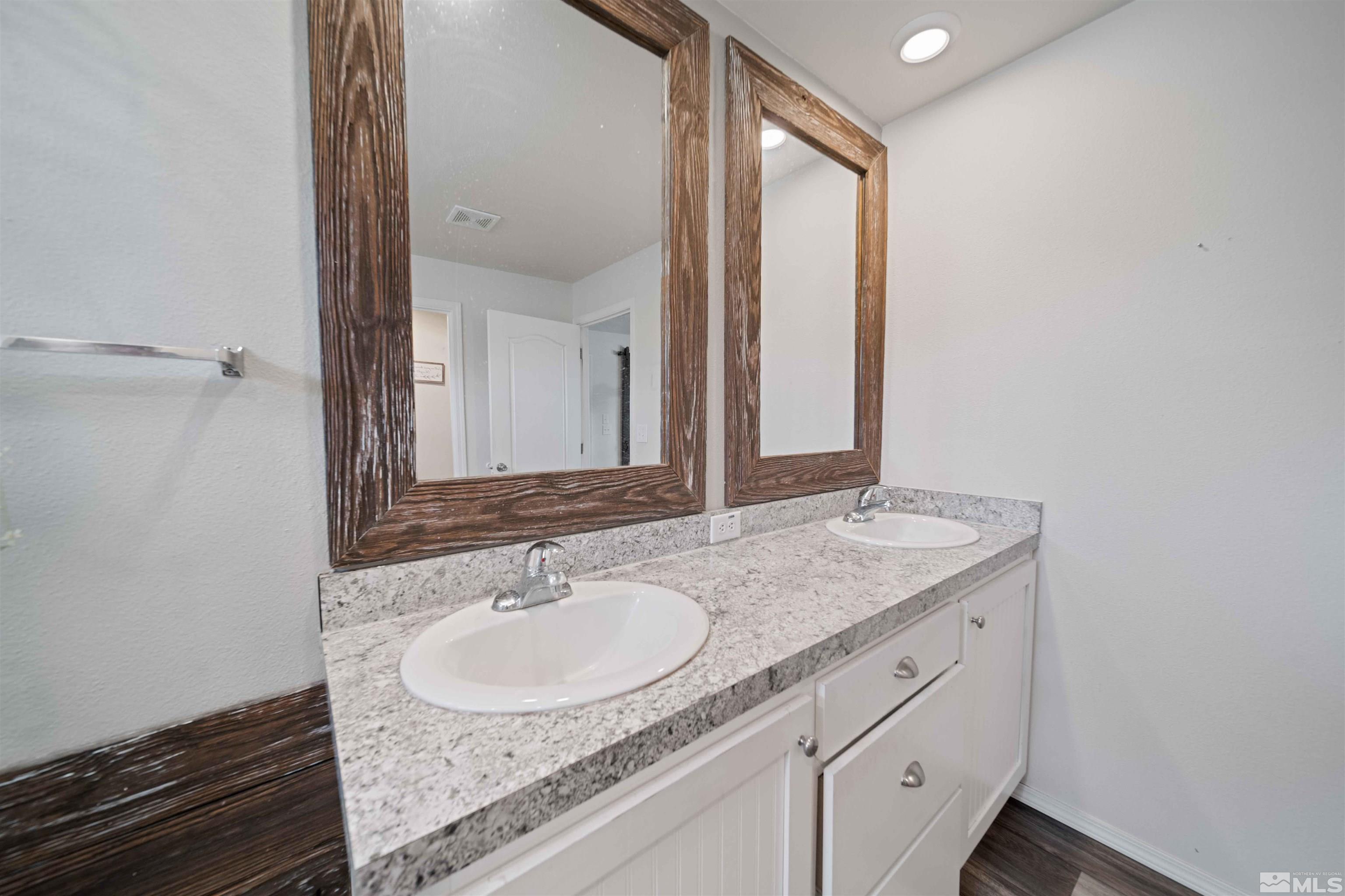 4020 Grouse Way Reno, NV 89508 - Photo 17 of 28 a bathroom with a granite countertop sink and a mirror