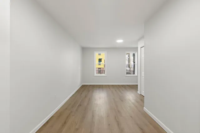 a view of an empty room and window and cabinet