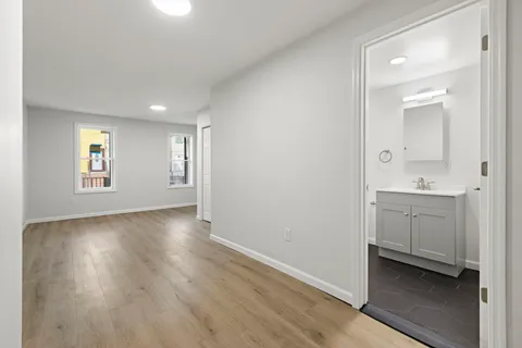 a bathroom with a bathtub shower sink mirror and toilet