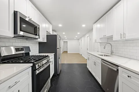 a kitchen with stainless steel appliances a sink stove and microwave
