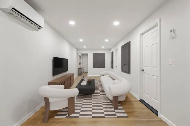 a living room with furniture a rug and a flat screen tv