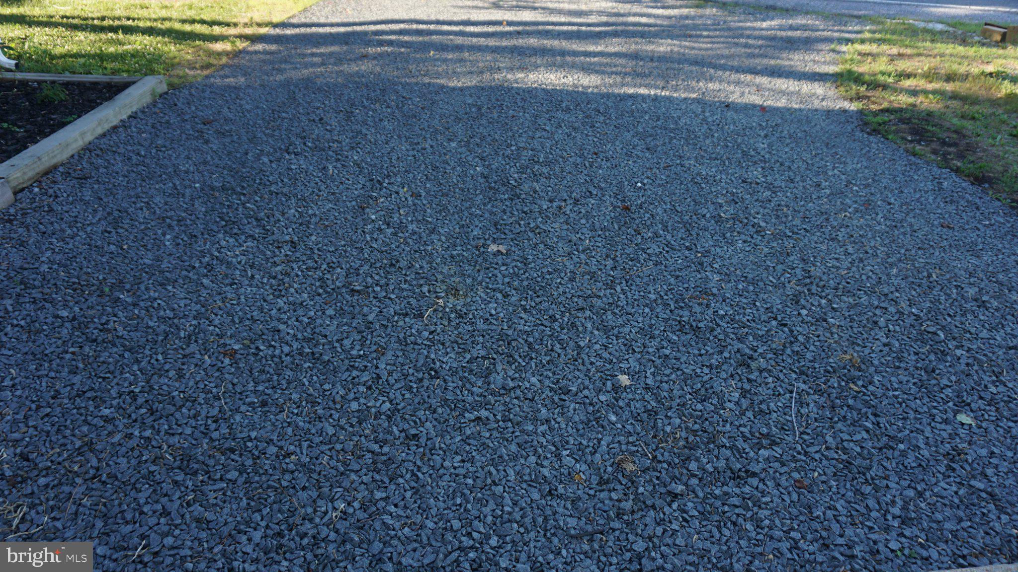 5854 Deale Churchton Road Deale, MD 20751 - Photo 6 of 57 Gravel driveway under soft sunlight.