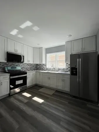 a kitchen with granite countertop a refrigerator stove and microwave