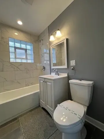 a bathroom with a sink a toilet a mirror and bathtub