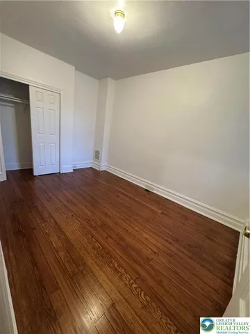 a view of an empty room with wooden floor