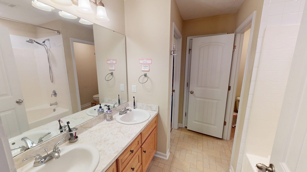 5260 Kingsberry Lane Columbus, GA 31907 - Photo 16 of 23 a en suite bathroom with a double vanity sink a mirror and a shower
