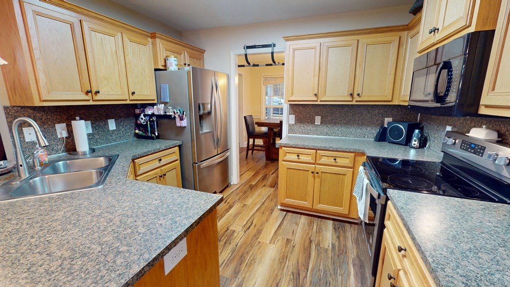 5260 Kingsberry Lane Columbus, GA 31907 - Photo 5 of 23 a kitchen with stainless steel appliances granite countertop a stove top oven a refrigerator and dishwasher with wooden floor