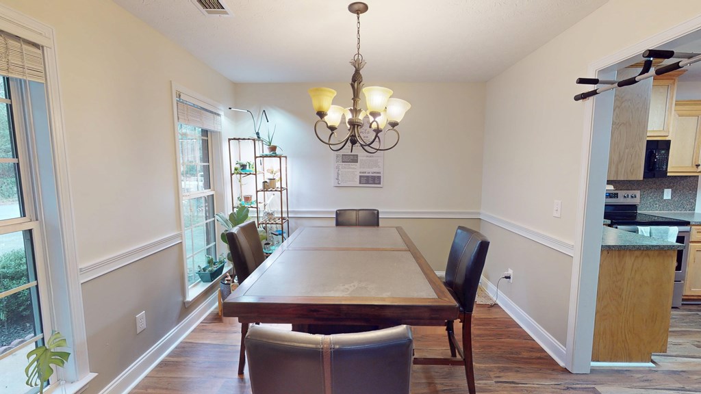 5260 Kingsberry Lane Columbus, GA 31907 - Photo 6 of 23 a dining room with wooden floor a chandelier a wooden table and chairs