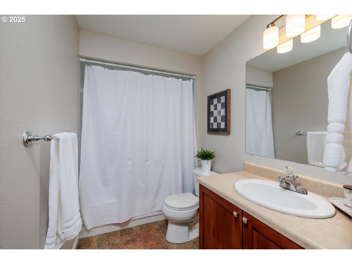 2610 Southwest 204th Avenue Beaverton, OR 97003 - Photo 23 of 37 a bathroom with a granite countertop sink toilet a large mirror and shower