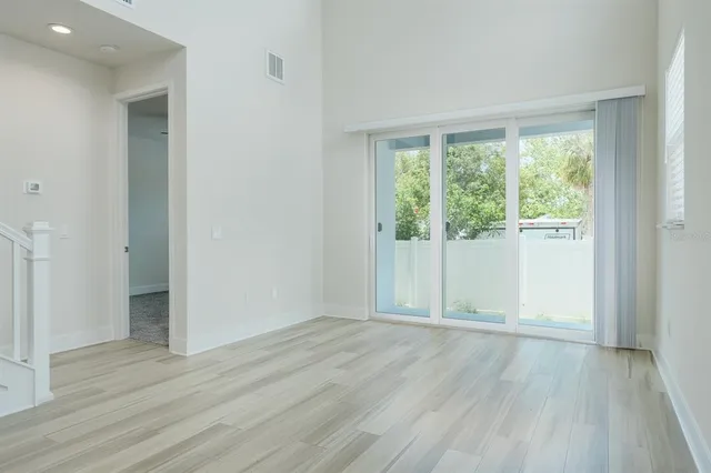 a large kitchen with stainless steel appliances granite countertop a stove a sink and a refrigerator with wooden floors