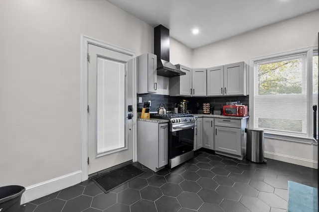 a kitchen with stainless steel appliances granite countertop a stove a sink and a refrigerator