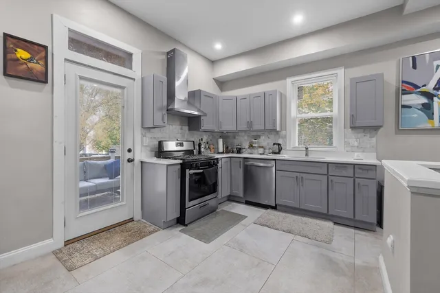 a kitchen with a sink window and stainless steel appliances