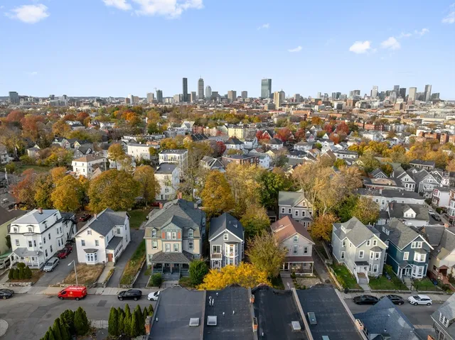 an aerial view of residential houses with outdoor space and parking