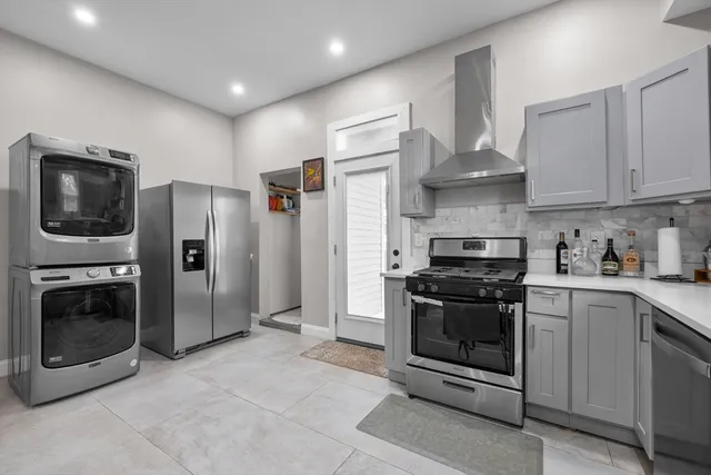 a kitchen with stainless steel appliances granite countertop a stove a refrigerator and a sink