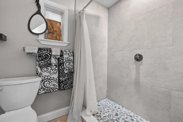 a bathroom with a toilet and a shower