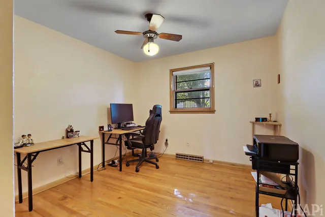a view of a workspace with furniture and a window