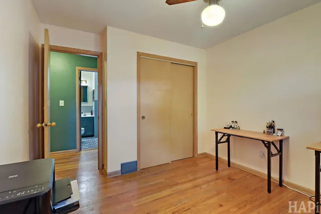 a view of a livingroom with wooden floor and a bathroom