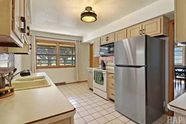 a kitchen with appliances a refrigerator a washer and dryer