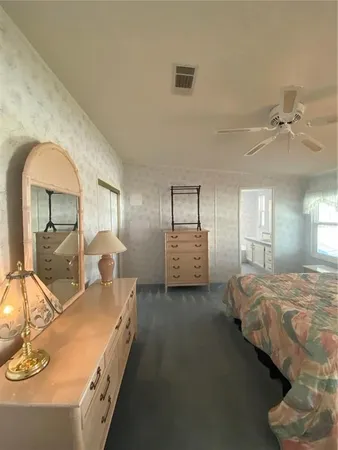 a spacious bedroom with a bed and a chandelier