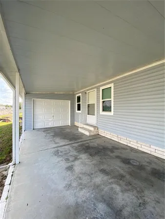 a view of a house with a yard and a large tree