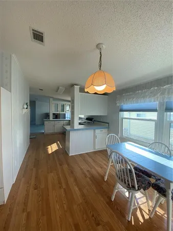 a view of a dining room with furniture a chandelier and wooden floor
